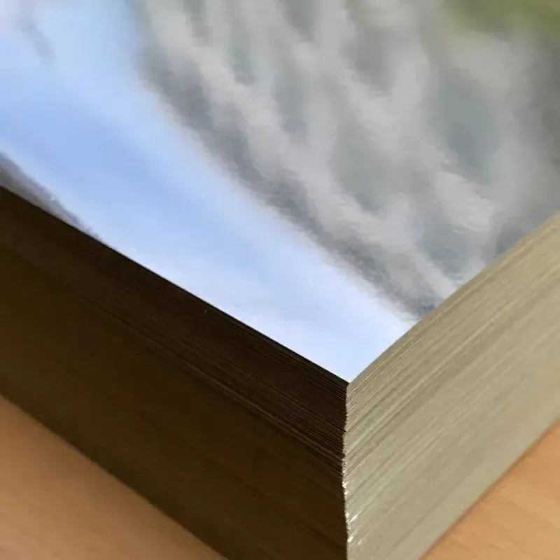 Close-up of glossy silver PET label sheet corner with reflective finish