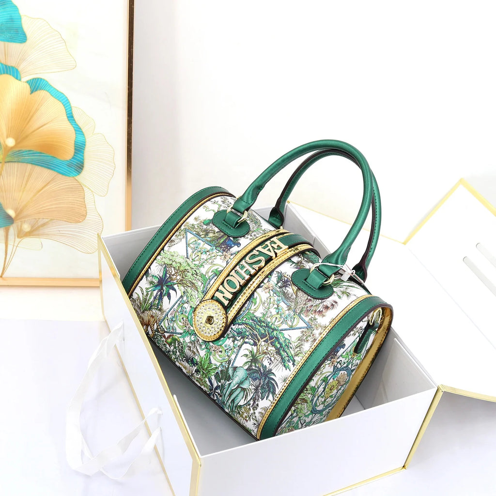 Green trunk handbag with tropical print, "FASHION" detail, and circular logo hardware. Stylish 29cm designer ladies bag.