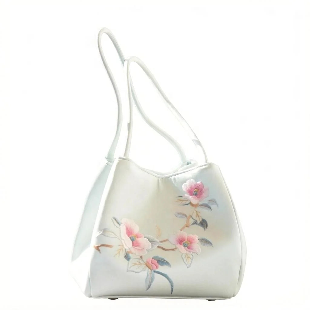 Lightweight white satin women's trunk purse featuring elegant floral Suzhou embroidery and dual shoulder straps.