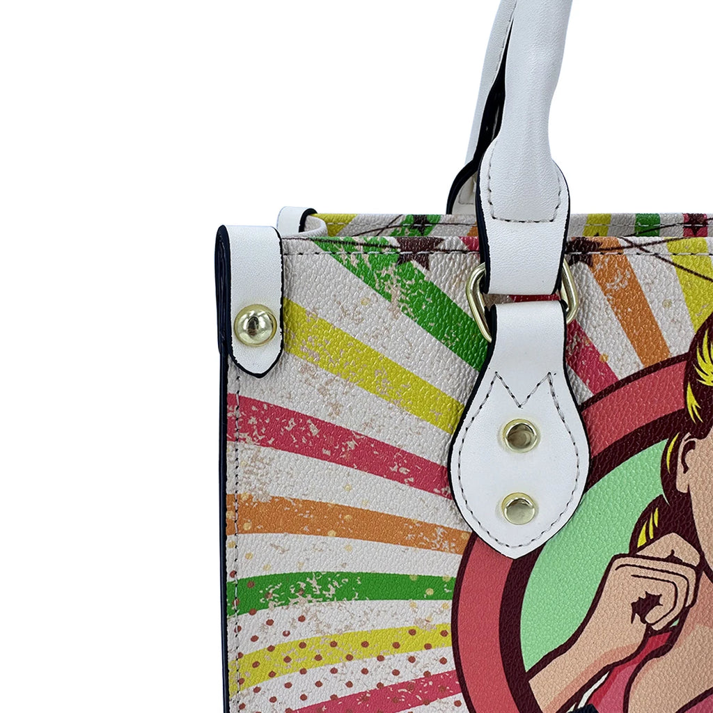 Vintage pop art leather trunk handbag with colorful sunburst print, white leather handles, and gold metal hook closure.