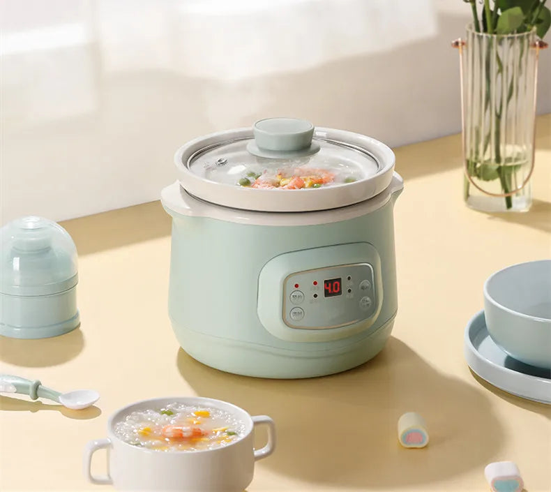 Mint 1L mini slow cooker with glass lid and digital display, showing interior food through lid