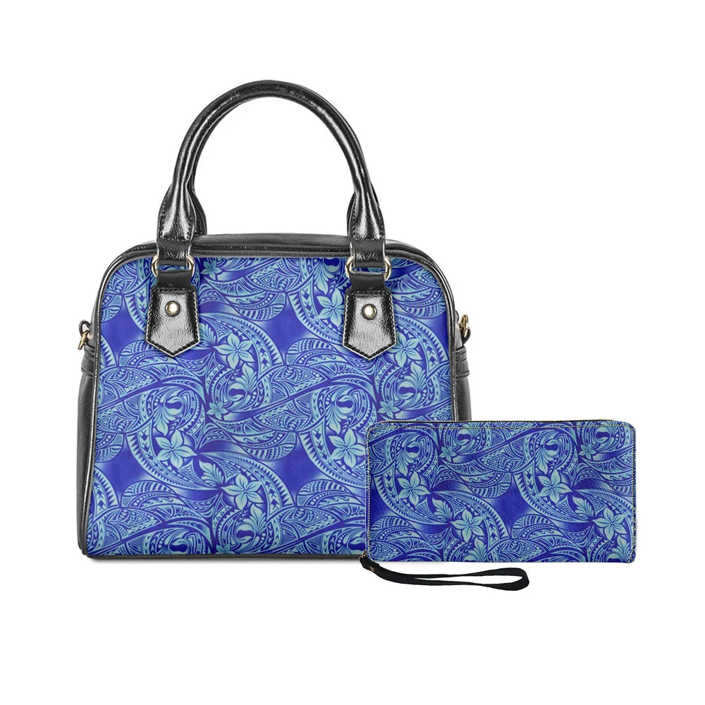 Blue Polynesian tribal print handbag and matching clutch set with black trim and elegant floral monster leaf motifs.