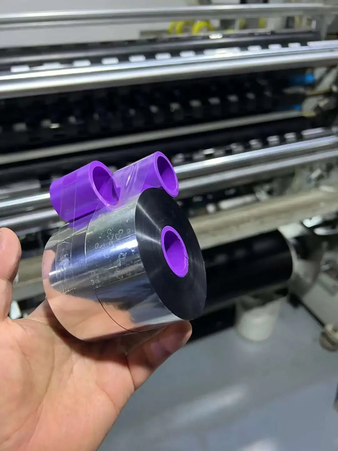 Hand-held black wax-resin thermal transfer ribbon roll with purple core