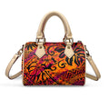 Orange and purple tribal print pillow handbag with beige top handles and detachable shoulder strap.