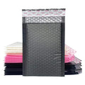 Black bubble mailer bag with top label strip; pink and black envelopes stacked