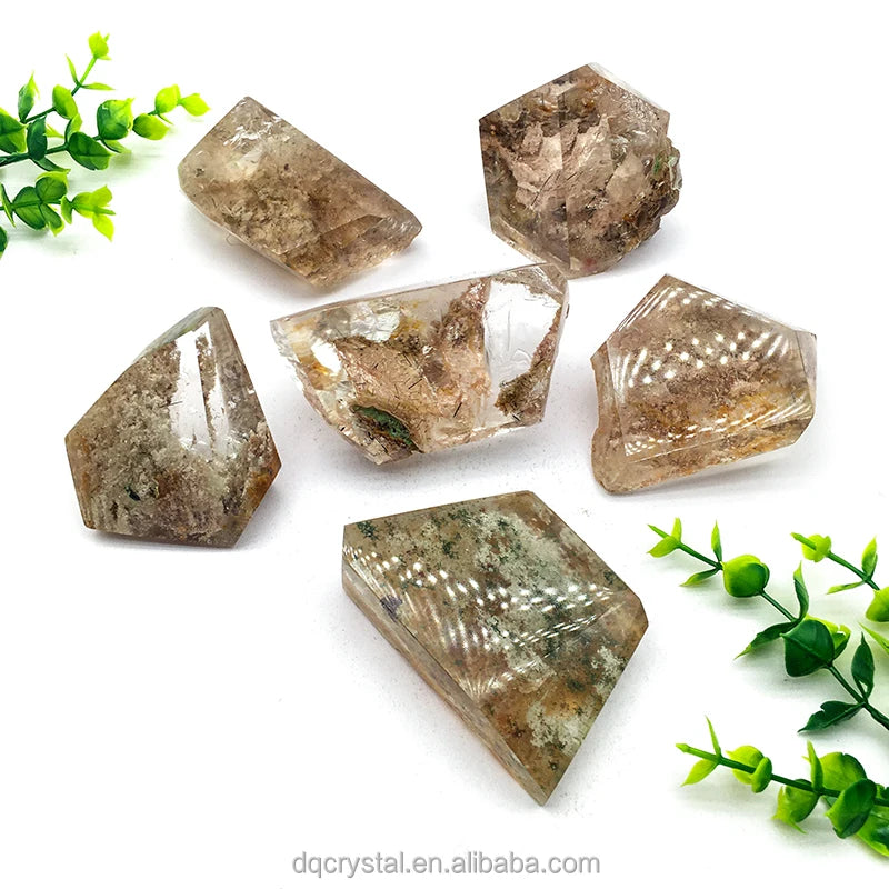 Mixed polished phantom quartz crystals with clear faces and golden-brown mineral inclusions