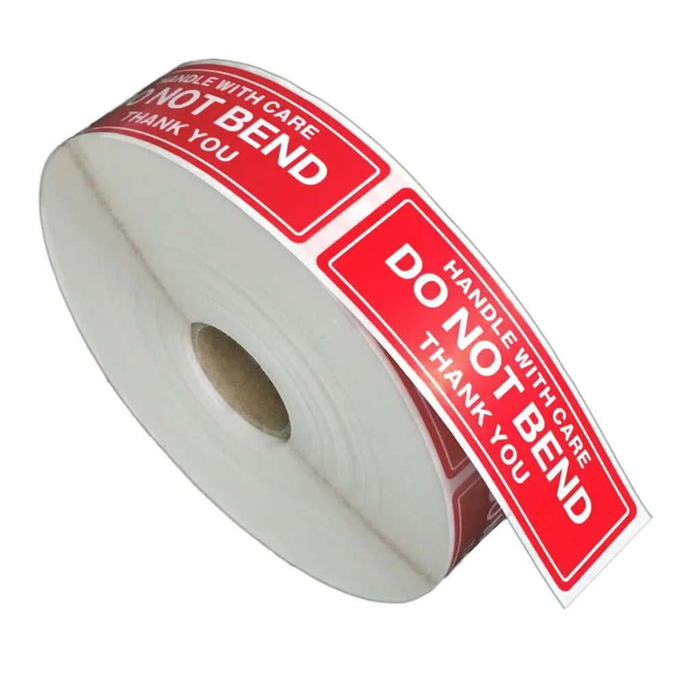 Roll of red warning shipping stickers reading “Handle with care” and “Do not bend”