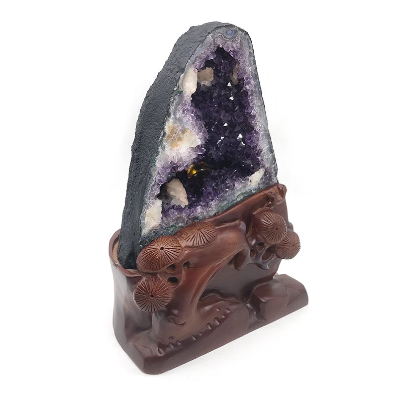 Purple amethyst crystal geode with carved brown base and floral relief details