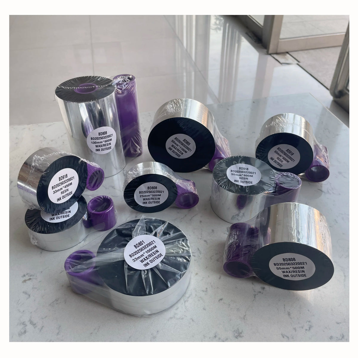 Set of black and silver TTO thermal ribbon rolls with purple film sleeves