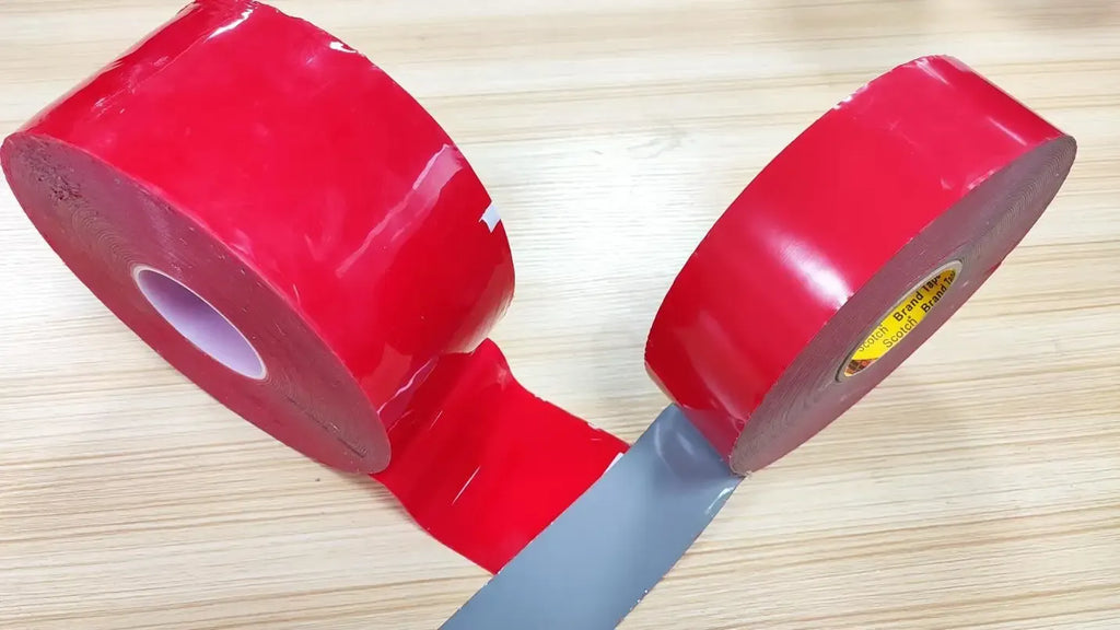 Double-sided carpet tape rolls with red adhesive strip unrolled