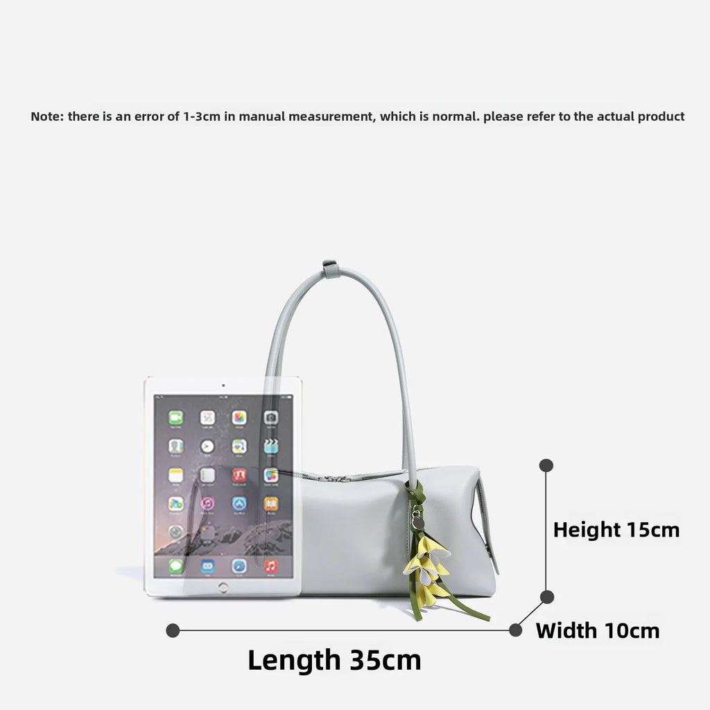 Light gray genuine cowhide leather underarm shoulder bag with zipper closure and decorative floral charm.