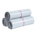White poly mailer rolls with pink bands, packaged in multiple layers