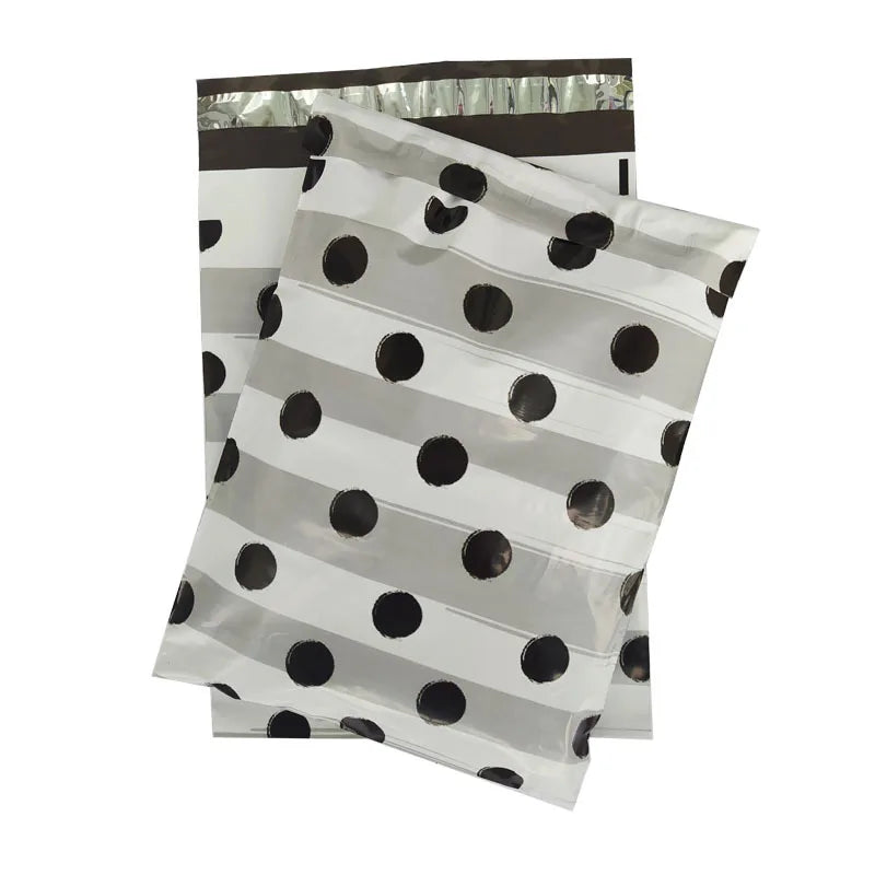 White poly mailing bag with black polka dots, stack with black handle strip