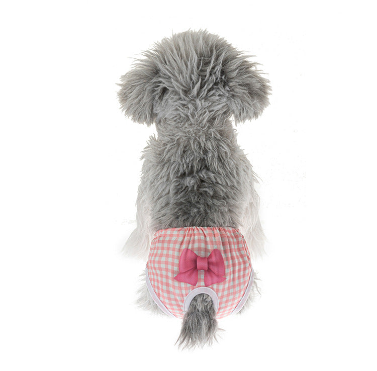 Small dog wearing a pink gingham reusable sanitary diaper with a bow, perfect for comfortable pet heat protection.