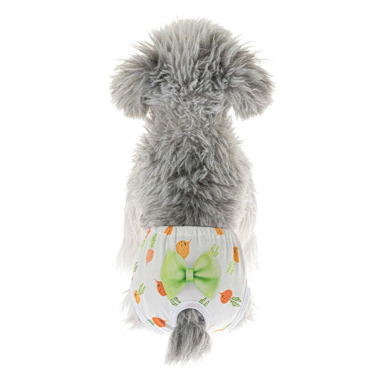 Small dog wearing cute carrot-print reusable sanitary diaper panty with green bow for female dog heat protection.