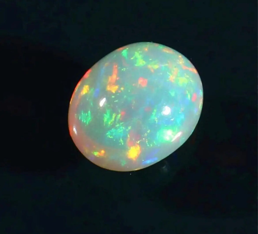 Oval opal cabochon with vivid green and white play-of-color, glossy dome.
