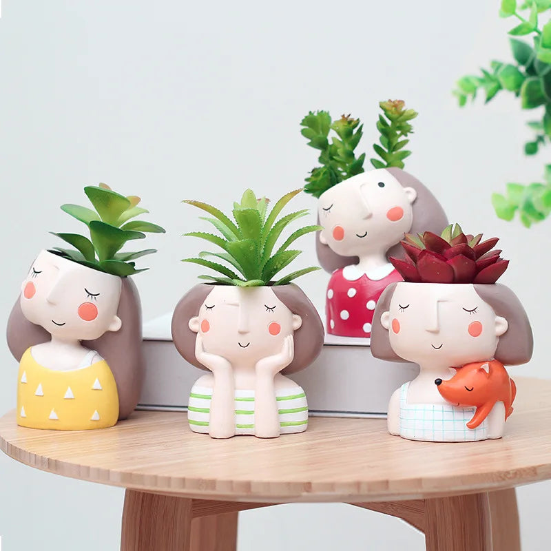 Set of four animal-face succulent planters on wooden tray with green plants