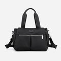 Minimalist black nylon designer handbag with silver zippers, top handles, and adjustable shoulder strap.