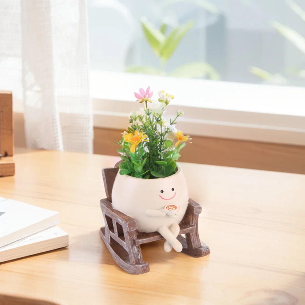Smiling rocking succulent pot planter with wooden chair base holding pink and orange flowers