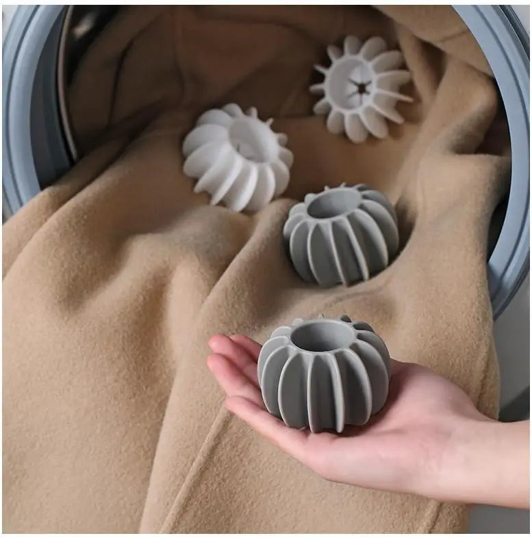 Reusable silicone laundry balls in gray and white for removing pet hair from clothes in the washing machine.