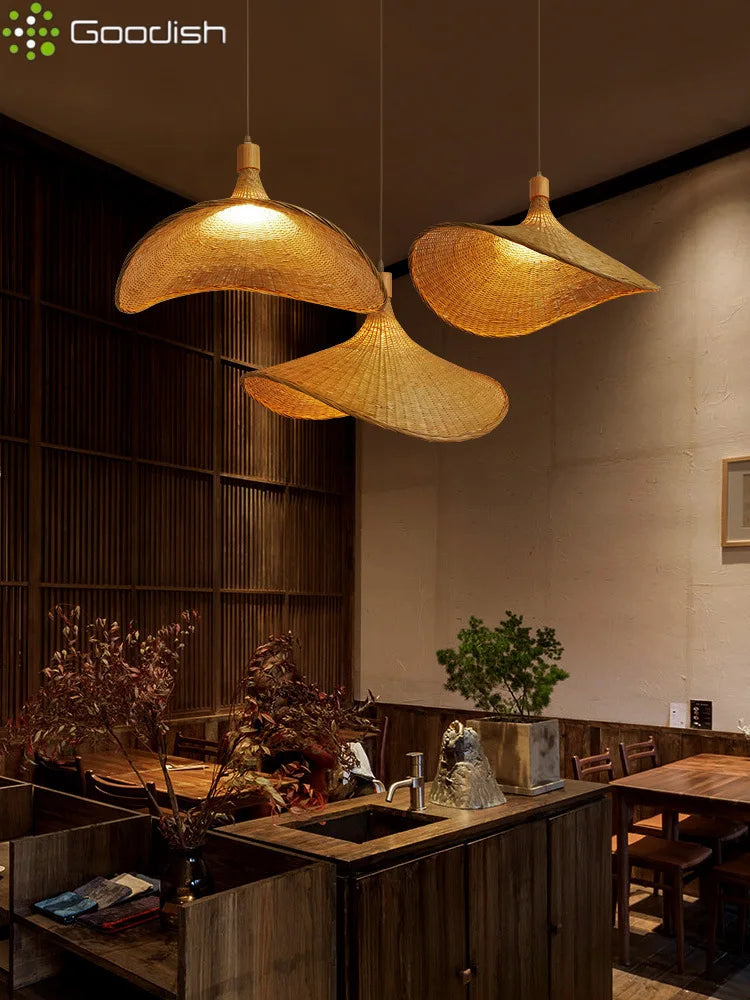 Three wide, conical woven bamboo pendant lights hanging over a dark wood kitchen counter in a rustic dining room.