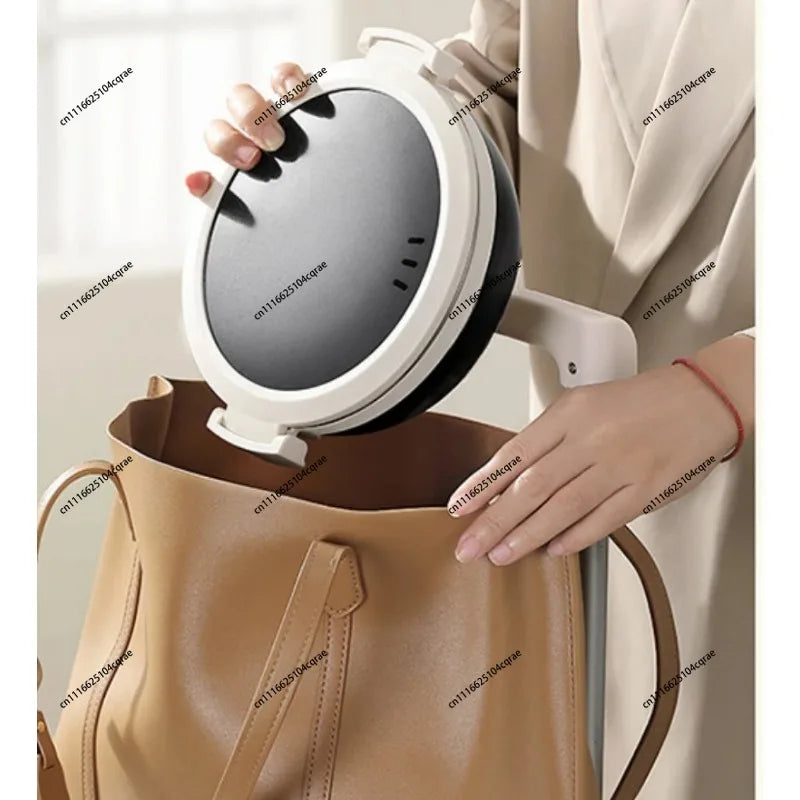 Folding electric cooking pot with black lid cover and white outer housing, ready to close