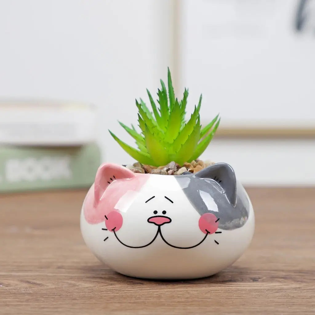 White animal-face ceramic planter with gray face and small green succulent plant