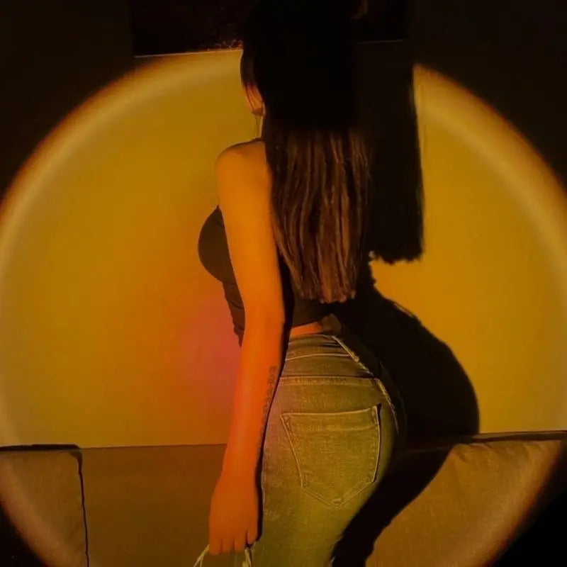 Sunset lamp casting a circular, warm golden light against a wall, used for room ambiance and photography lighting.