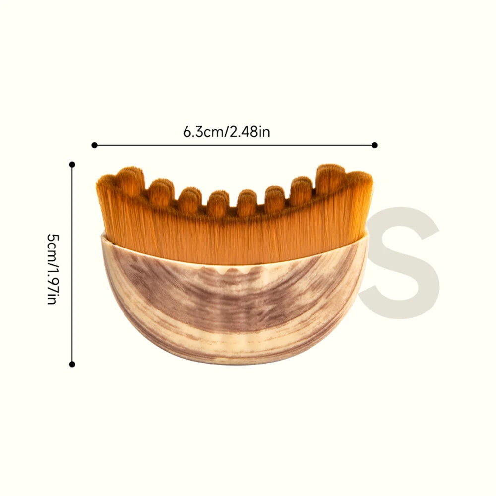 Crescent-shaped face brush with a wood-grain base and brown, undulating synthetic bristles, shown with size dimensions.