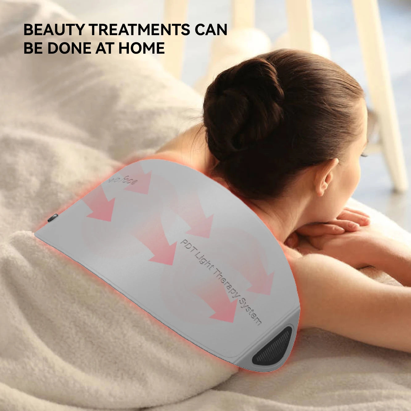 A person lies on their back using a flexible, grey Hello Face PDT infrared light therapy panel on their shoulder.