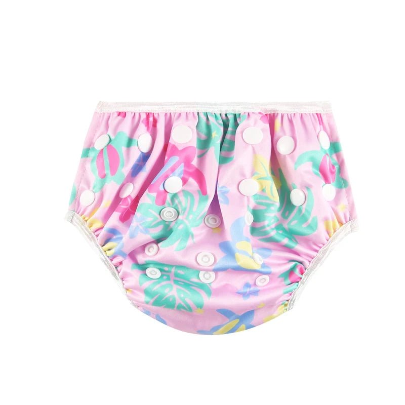 Reusable baby swim diaper, pink tropical leaf print with adjustable snap buttons for infant baby care.