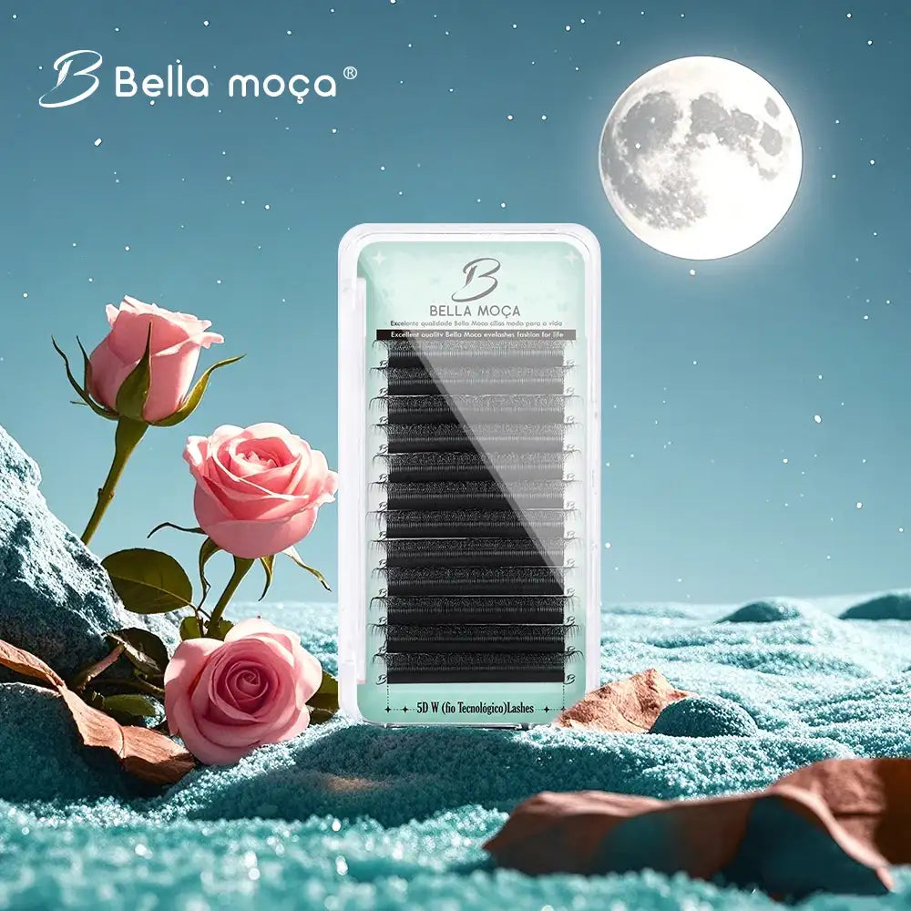 A tray of black 5D W-style volume lashes set against a surreal night sky with a moon, rocks, and pink roses.