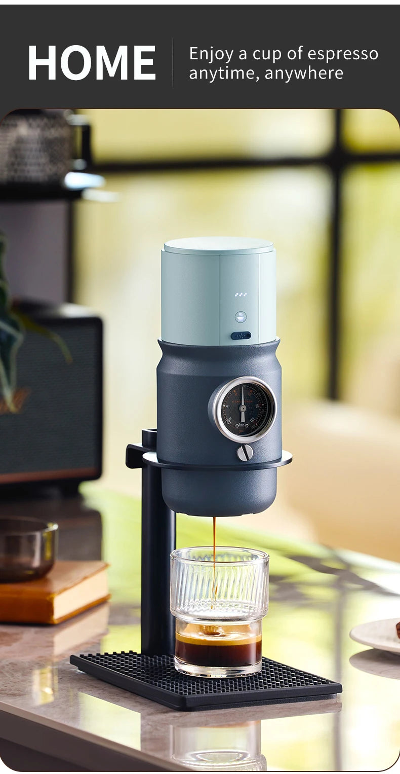 Portable blue espresso maker with pressure gauge brewing into a ribbed glass cup on a black stand.
