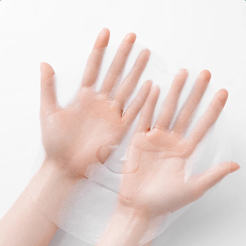 Hands holding a thin, translucent white disposable facial mask sheet against a plain background.