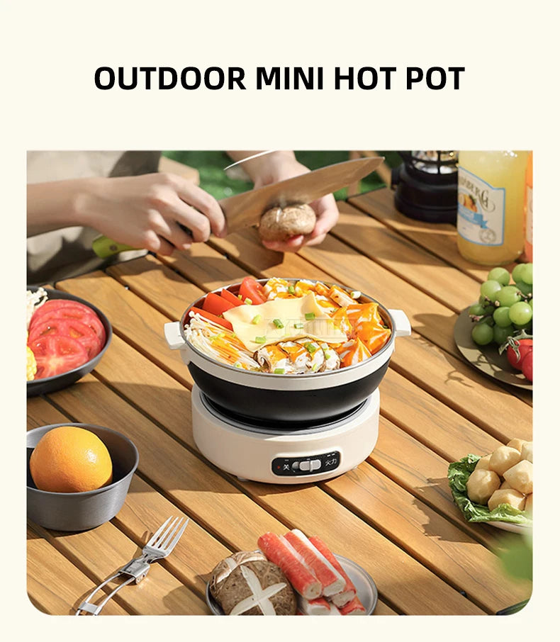 Portable electric mini hot pot with black bowl and white base, outdoor cooking setup