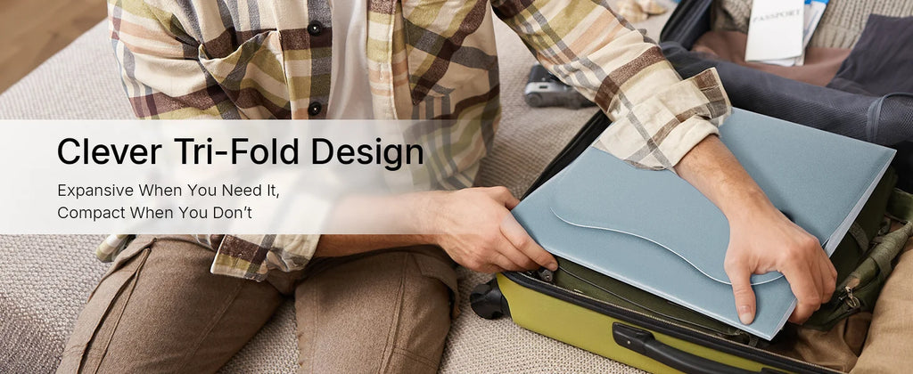 A person packing a blue, tri-fold Hello Face red light therapy mat into a carry-on suitcase.