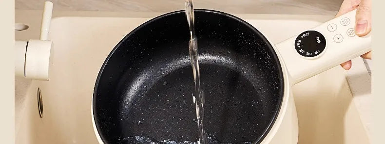 Black non-stick cooking pot interior with stream of water being poured
