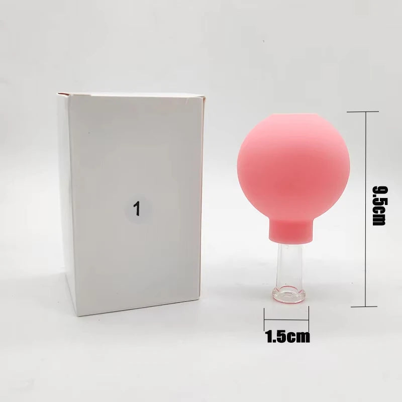 Pink rubber vacuum facial cupping tool with a clear glass base next to a white box, featuring dimension labels.