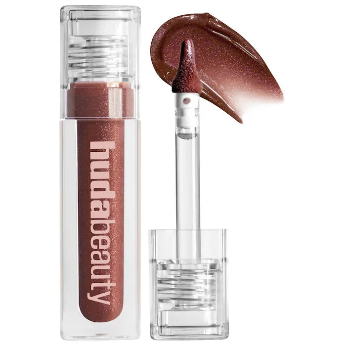 Huda Beauty shimmering brown liquid lipstick and cheek tint with applicator wand and creamy textured product swatch.