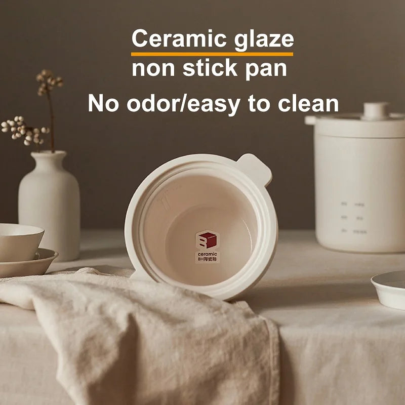White rice cooker with open ceramic inner lid showing nonstick pot bottom