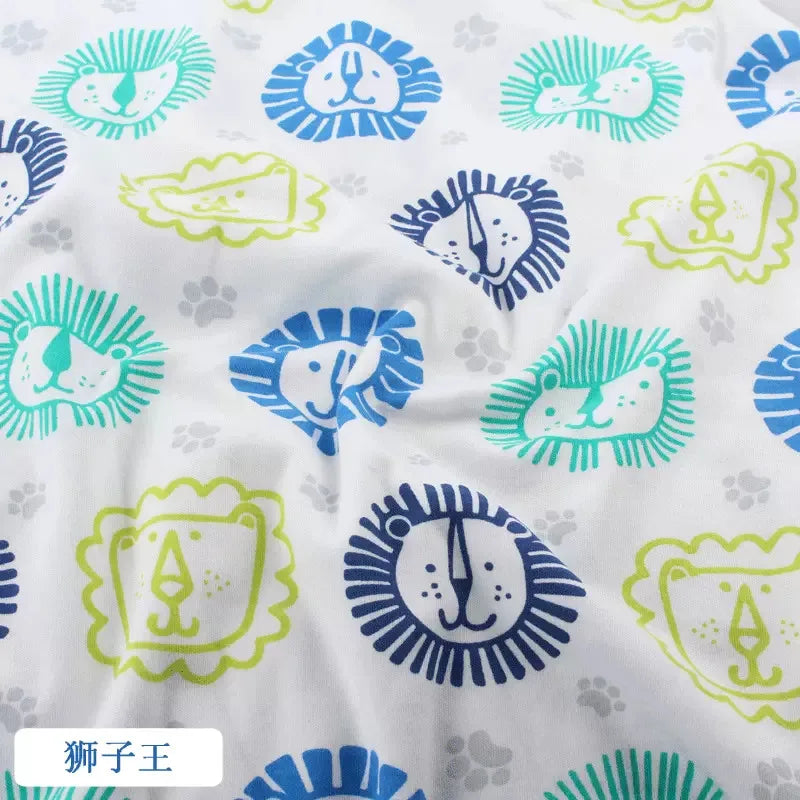 Tidesmit white organic knit fabric with blue and lime green cartoon lion face print and small grey paw prints.