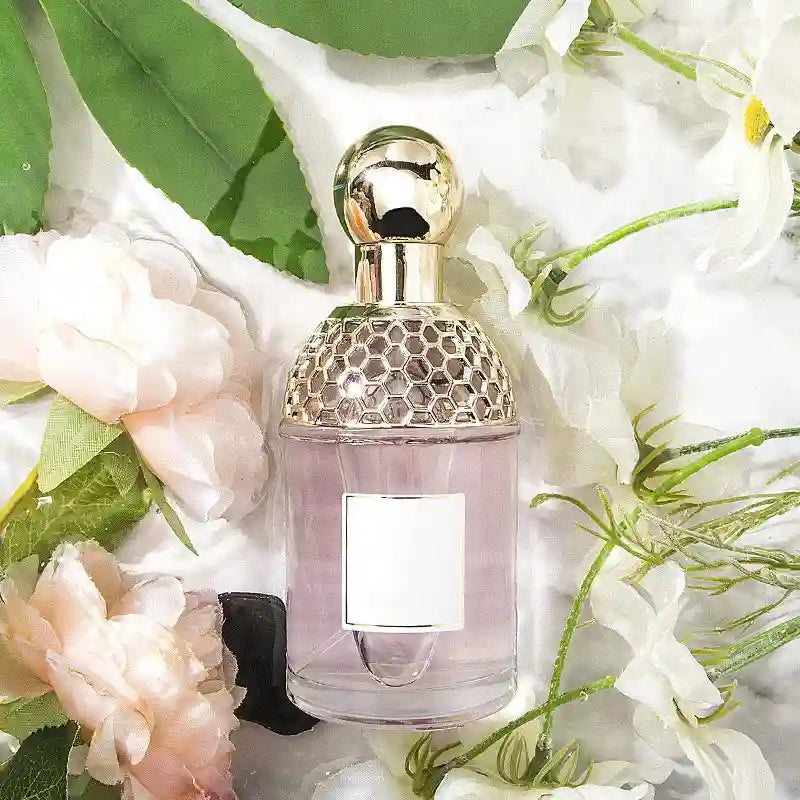 Flora Water Women's EDT: Floral fruity summer scent in a 100ml honeycomb-cap glass bottle surrounded by fresh flowers.