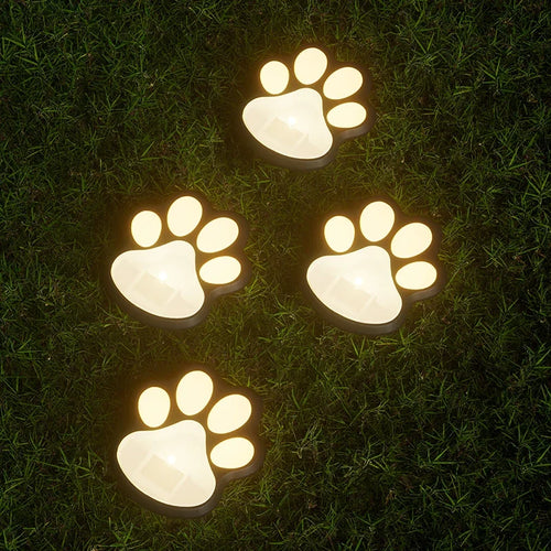 Solar paw-shaped LED garden lights, four warm glowing paw prints on the lawn