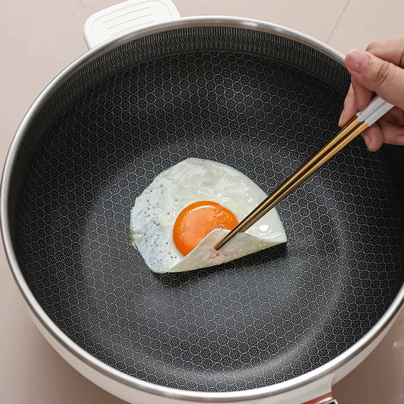 Electric frying pot inner bowl with dark nonstick honeycomb coating and egg in pan