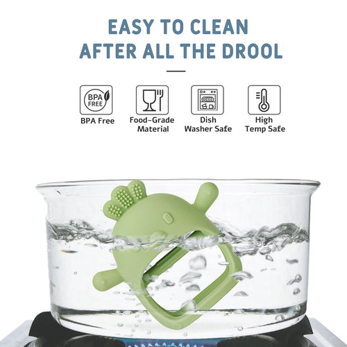 Green silicone baby teething toy being sanitized in boiling water for easy cleaning.