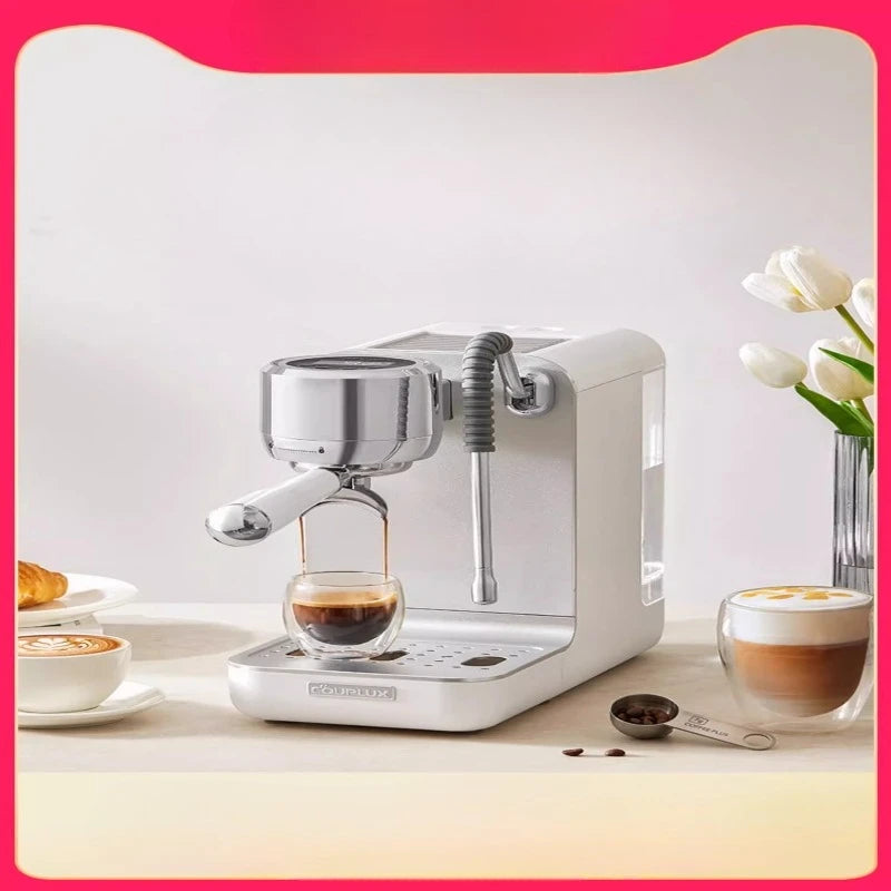 Couplux white espresso machine with chrome accents, milk frothing wand, and glass cup on a tabletop.