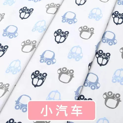 White knit fabric with repeating dark blue, light blue, and gray car print for baby clothing.