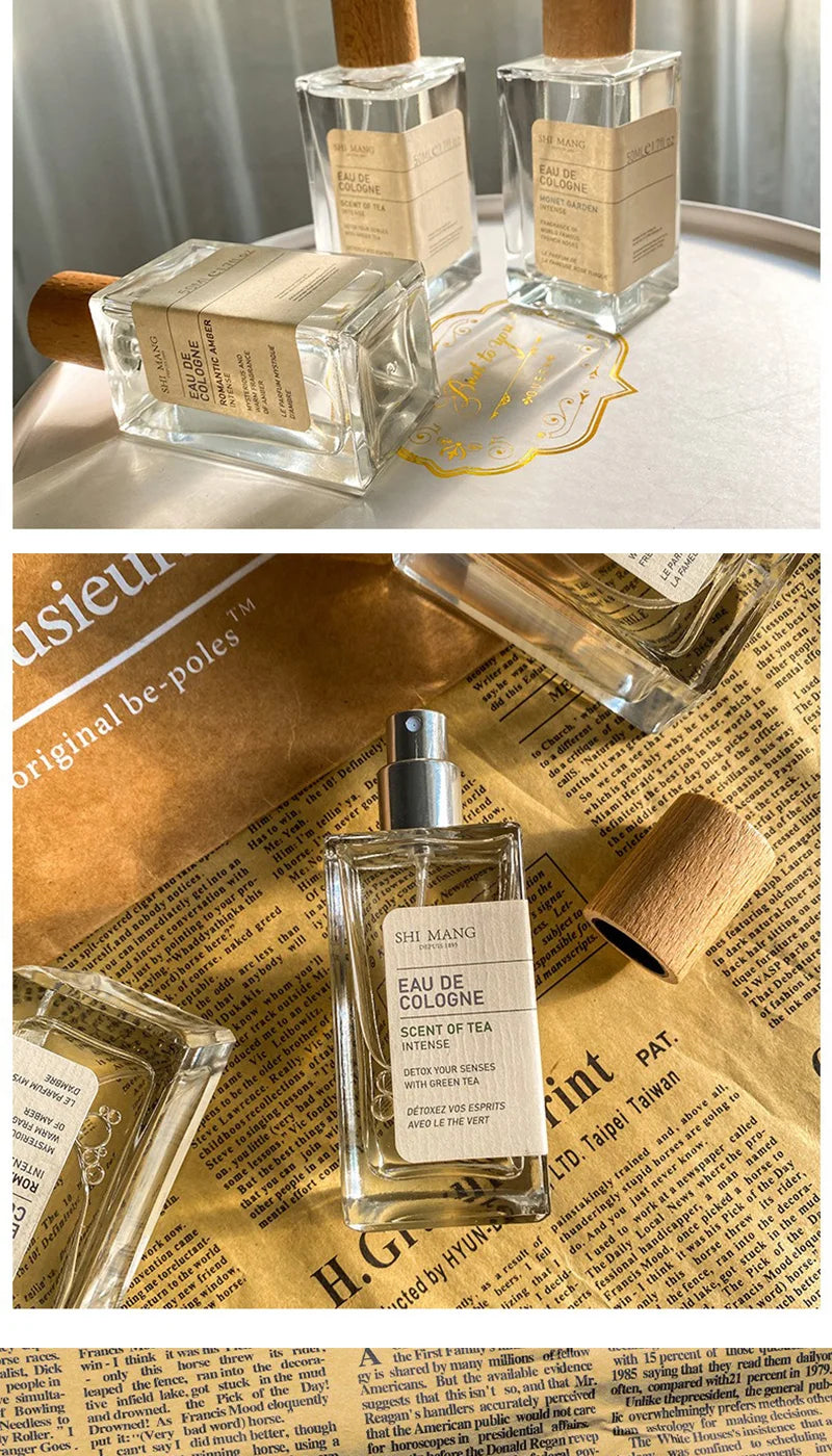 Three rectangular glass eau de cologne bottles with wooden caps and beige labels, arranged on decorative paper.