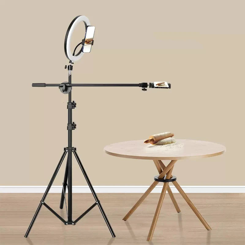 Black metal tripod stand with an overhead boom arm, ring light, and phone holder for top-down video recording.