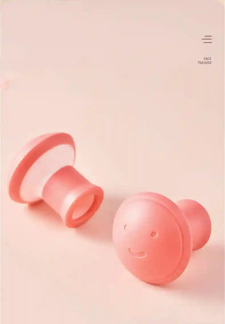 Two pink, mushroom-shaped silicone facial exercisers with smiley faces on a light pink background.